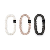 Set of three Silk Works mulberry silk scrunchies in ivory, caramel, and charcoal grey – soft, gentle, and perfect for everyday styling