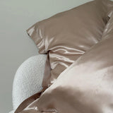 Caramel 100% mulberry silk pillowcase on boucle chair – smooth, anti-frizz silk bedding by Silk Works London