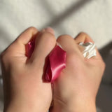 User-generated video showing close-up unboxing of Silk Works Watermelon Sugar silk scrunchies being modelled by blonde girl
