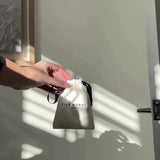 user generated video of a girl unboxing the silk skinny scrunchies in neutral. Grey, ivory and caramel colours. The packaging is minimalist and luxurious, reflecting a thoughtful gifting experience