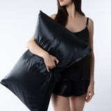 woman holding black silk pillowcase