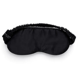 Black mulberry silk sleep mask by Silk Works with soft ruched strap and discreet logo tag, designed for light blocking and skin comfort.