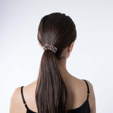 Model wearing Silk Works leopard print silk scrunchie in a sleek low ponytail, showcasing gentle hold and frizz-free finish.