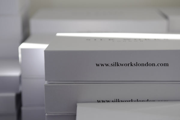 White silk works london pillowcase gift boxes stacked in a pile.