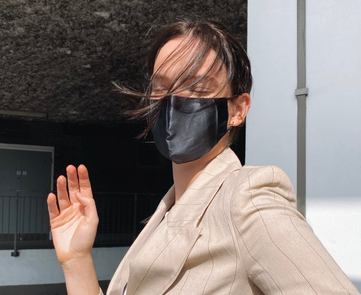 Lady wearing black silk face mask.
