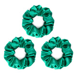 Three large bright green silk scrunchies.