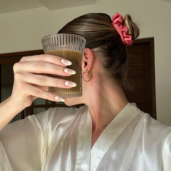 Ladey wearing a watermelon coloured silk scrunchie in her hair.