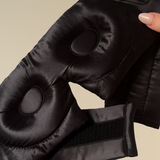 Close detail of adjustable strap and padded interior of black silk eye mask – designed for comfort