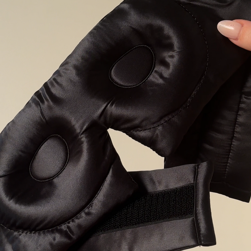 Close detail of adjustable strap and padded interior of black silk eye mask – designed for comfort