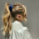 Lady wearing a large sapphire blue silk scrunchie in her hair.