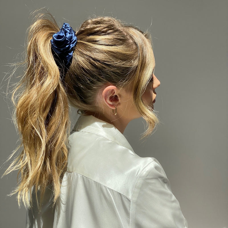 Lady wearing a large navy blue mulberry silk scrunchie in her hair.