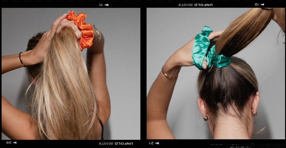 Lady with long blonde hair tying her hair up with a large orange silk scrunchie and a green silk scrunchie.