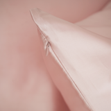 Close-up of a soft pink silk pillow with a blurred background