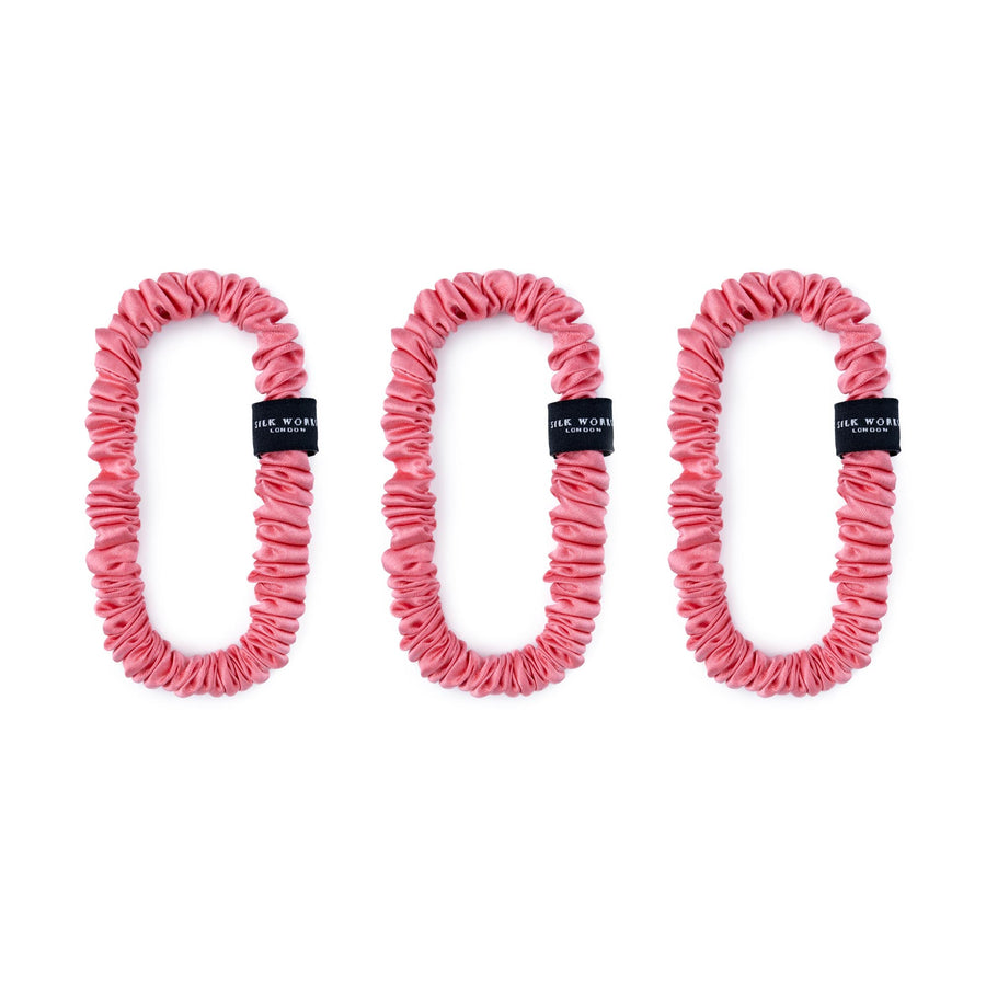 Trio of watermelon pink 100% mulberry silk skinny scrunchies by Silk Works, designed to reduce breakage and frizz.