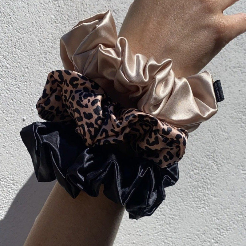 Set of three silk scrunchies on wrist, leopard, caramel and black, carame