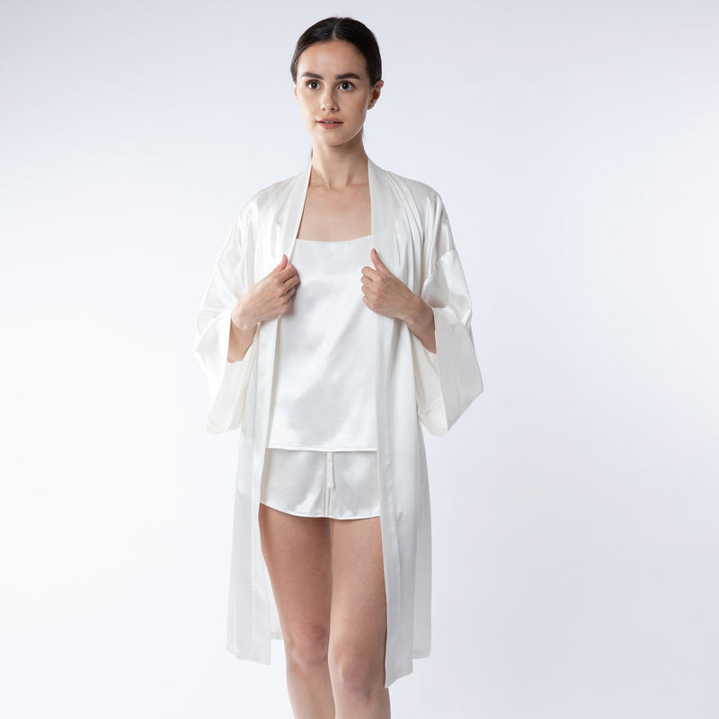 Lady wearing silk ivory shorts, camisole and robe