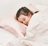 little girl sleeping on a pink silk pillowcase, toddler size