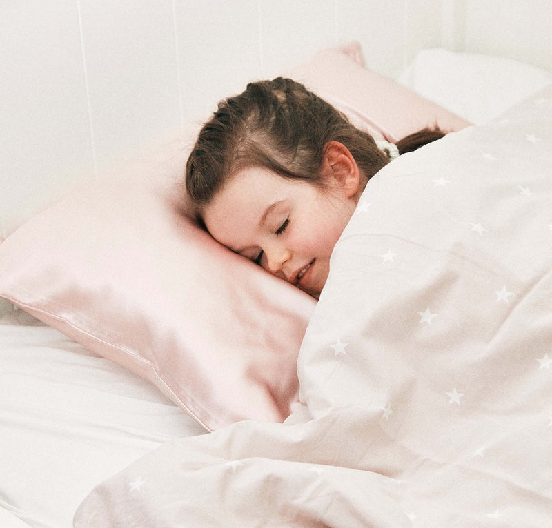 little girl sleeping on a pink silk pillowcase, toddler size