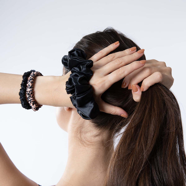 Large black mulberry silk scrunchie worn on a model's wrist – showcasing its soft texture and elegant design for a stylish accessory.