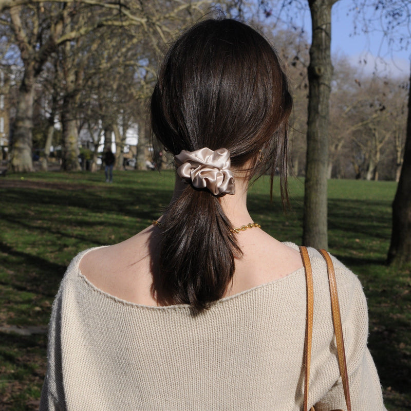 Model wearing a large caramel silk scrunchie in her hair – elegant, neutral-toned accessory made from soft mulberry silk